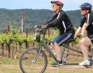 Two people ride a tandem bike.