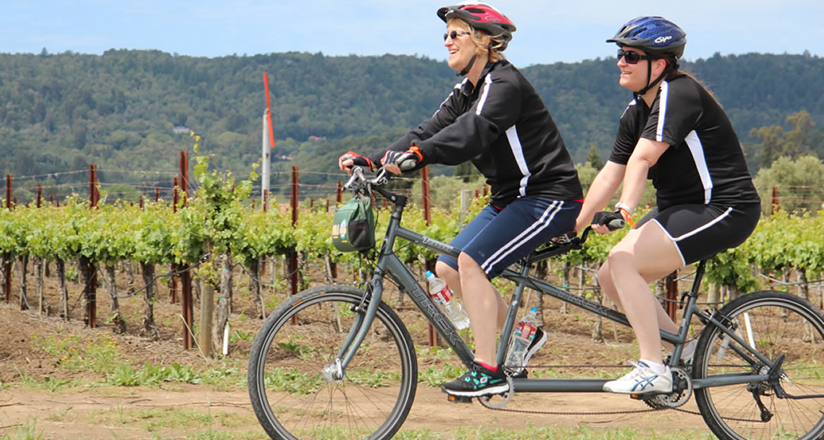 Two people ride a tandem bike.
