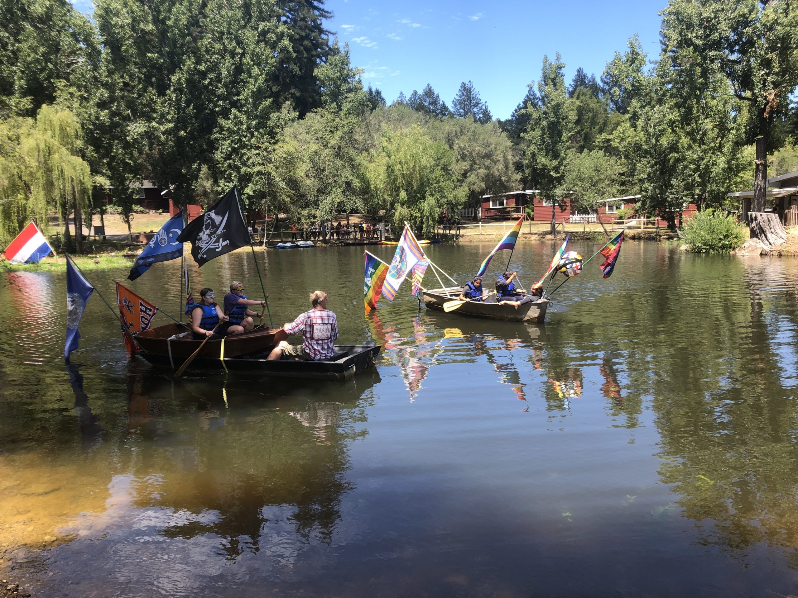 Teens row boats on Lake Lakoya at Enchanted Hills Camp
