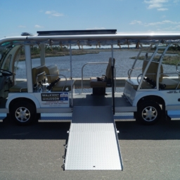 A white electric shuttle bus with wheelchair ramp extended