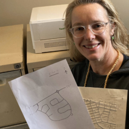 TMAP down under Orientation and Mobility specialist, Anegla Reynolds, poses with two TMAPs she has embossed for clients in Australia
