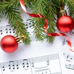 holiday concert An image of sheet music, red ribbon, a red ornament, and pine tree branches