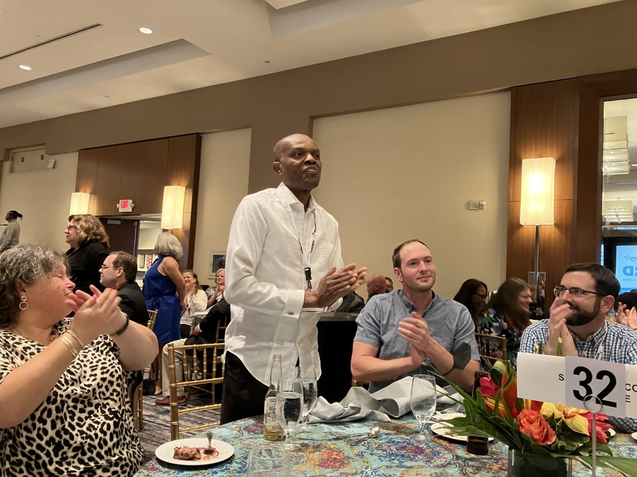 Dr. Charles Umo stands at a table at the 2022 NIB Conference