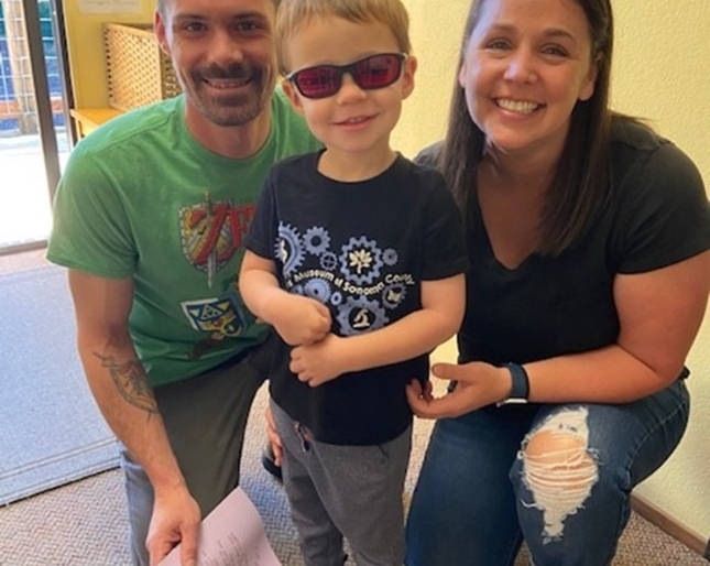 Dad, Little Learner and Amy kneel for a photo. Little Learner wears sunglasses