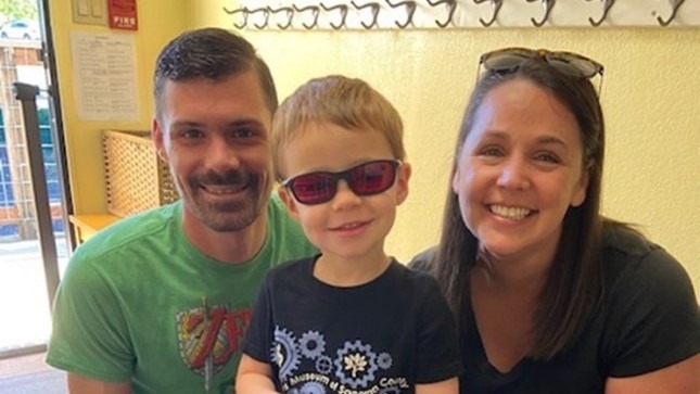 Dad, Little Learner and Amy kneel for a photo. Little Learner wears sunglasses