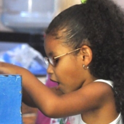 Little Learners piano cropped A little girl wearing glasses plays on a toy piano