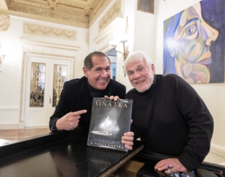 Alex and Steve smile and hold the book, Frank Sinatra: An American Legend by Nancy Sinatra.