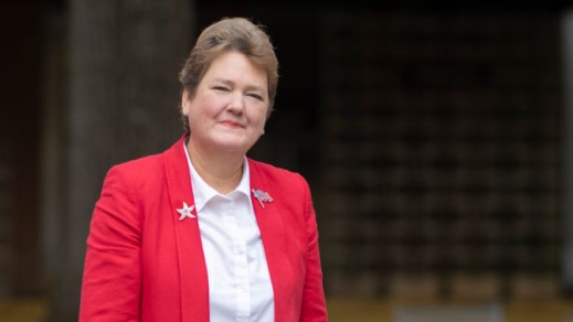Sharon Giovinazzo in a dark pink suit with a white blouse