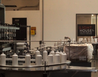 A shot of the manufacturing floor inside the LightHouse Sirkin Center, an employee with a white cane can be seen in the background