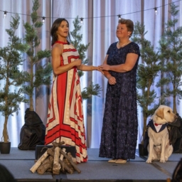 Keynote Speaker Rebecca Alexander and LightHouse CEO Sharon Giovinazzo stand together on stage - the stage is decorated with pine trmees and bistro lights to bring the essence of camp to the Grand Ballroo