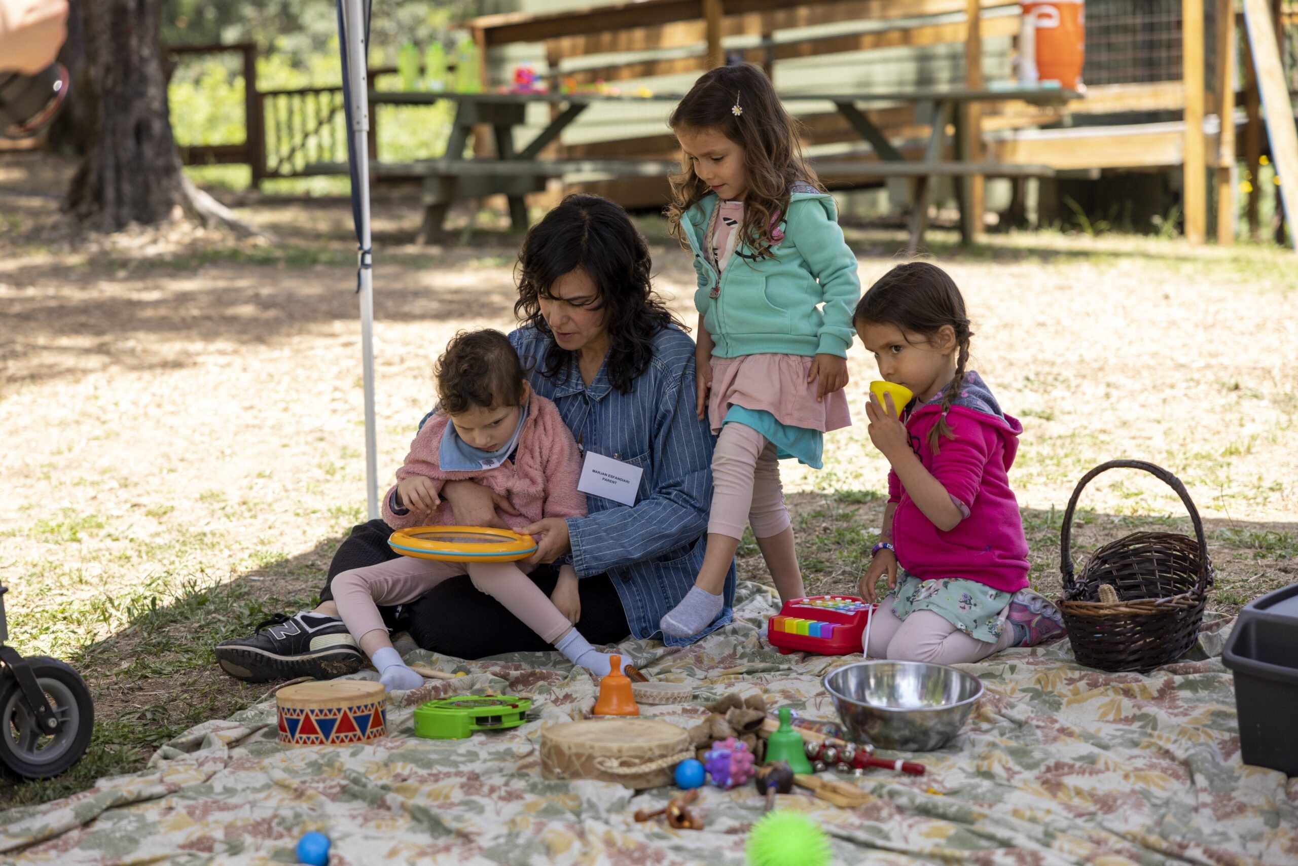 Little Learers and a parent playing on a blanket at Little Learners Family Camp