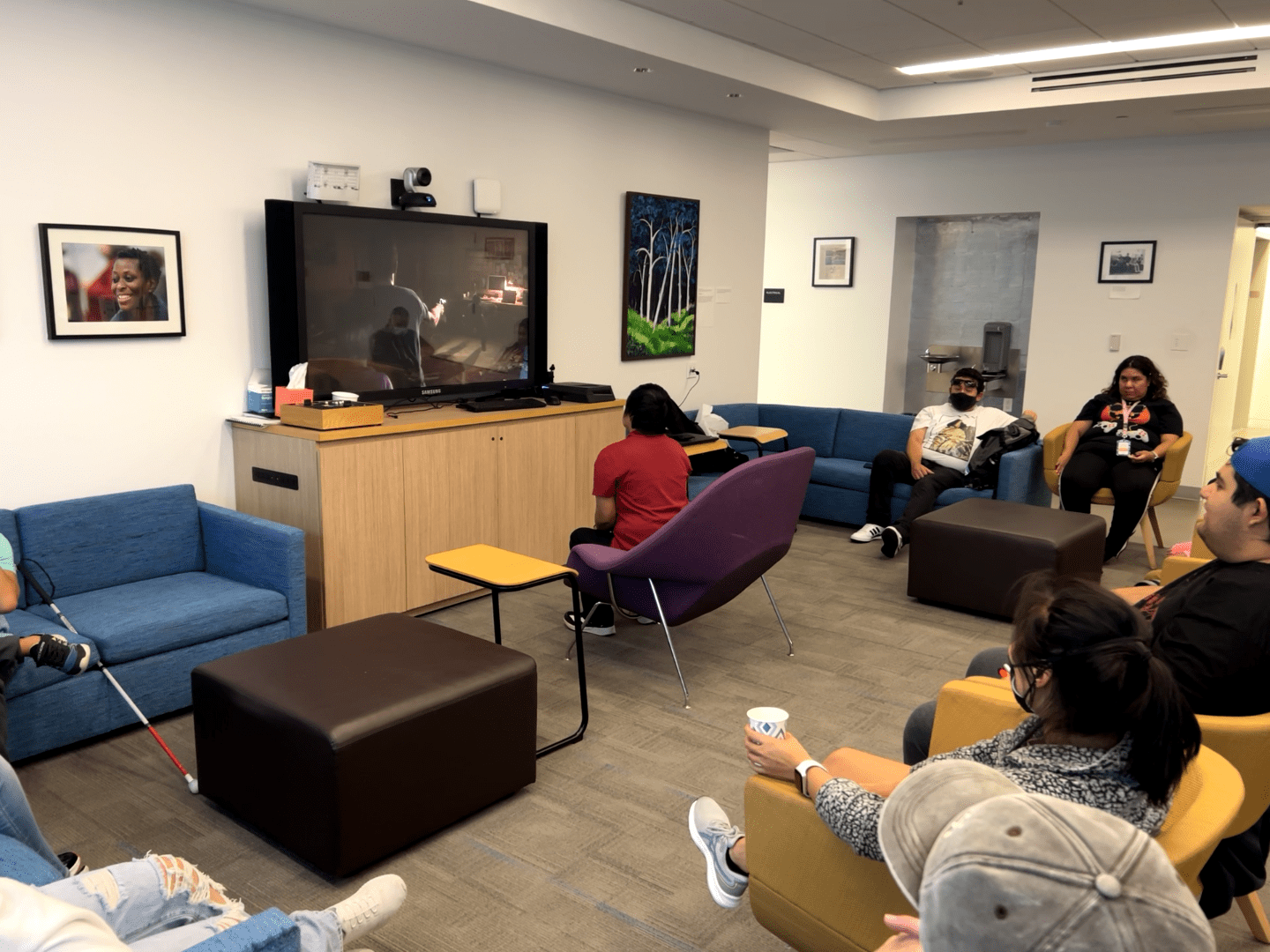 A LightHouse student plays a video game while others observe