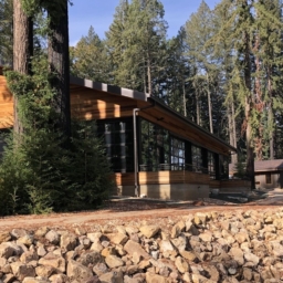 A new structure at EHC with external wood paneling, large windows, and is surrounded by redwood trees and newly paved paths