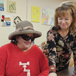 Cathy, right, stands and smiles as she watches a client