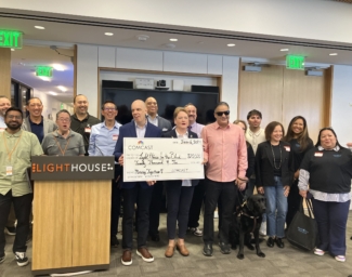 LightHouse staff and the Xfinity Accessibility team pose together at the LightHouse HQ with a giant check for $20k.