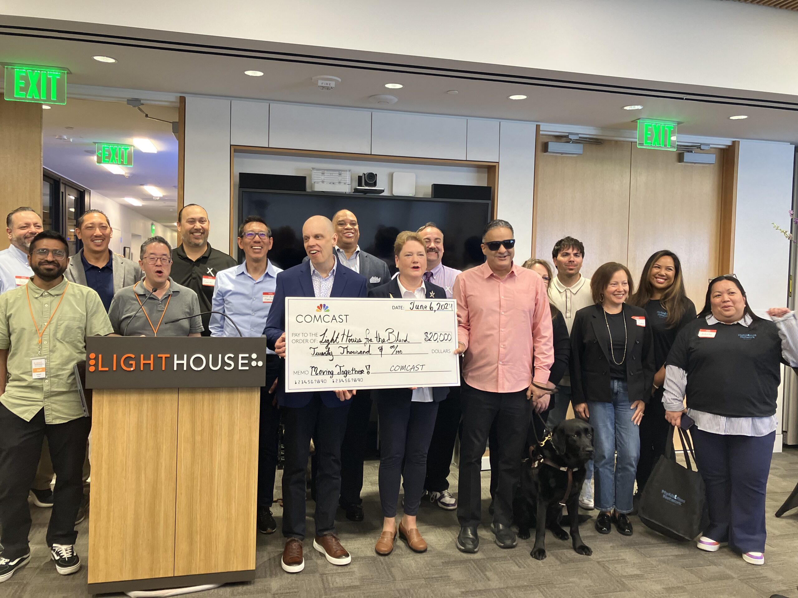 LightHouse staff and the Xfinity Accessibility team pose together at the LightHouse HQ with a giant check for $20k.