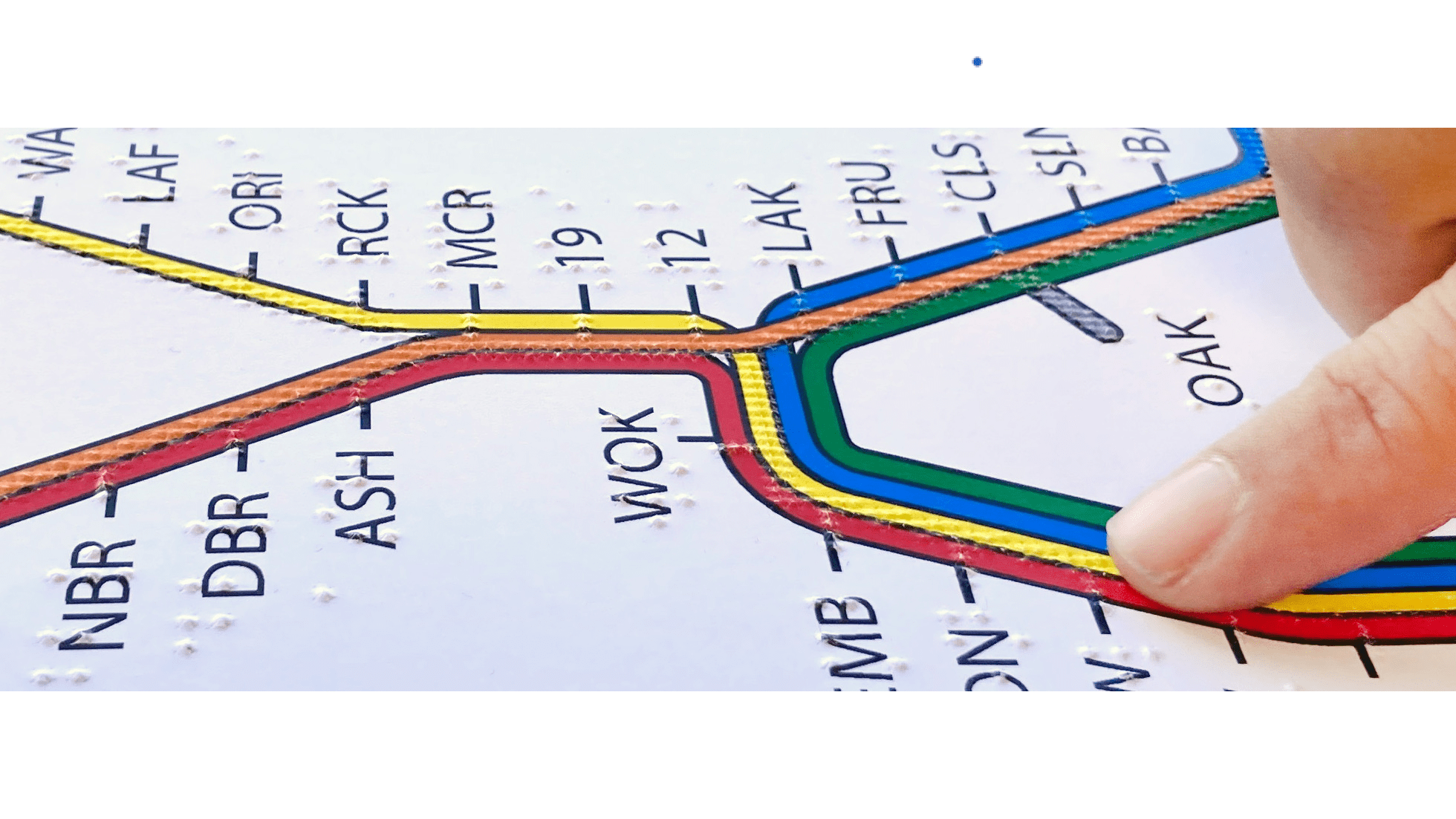 A finger explores a tactile BART system map.