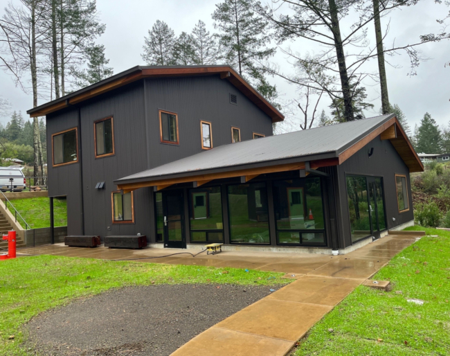 EHC Two Story Structure A large, two-story structure with lots of large windows and a freshly paved path leading up to it
