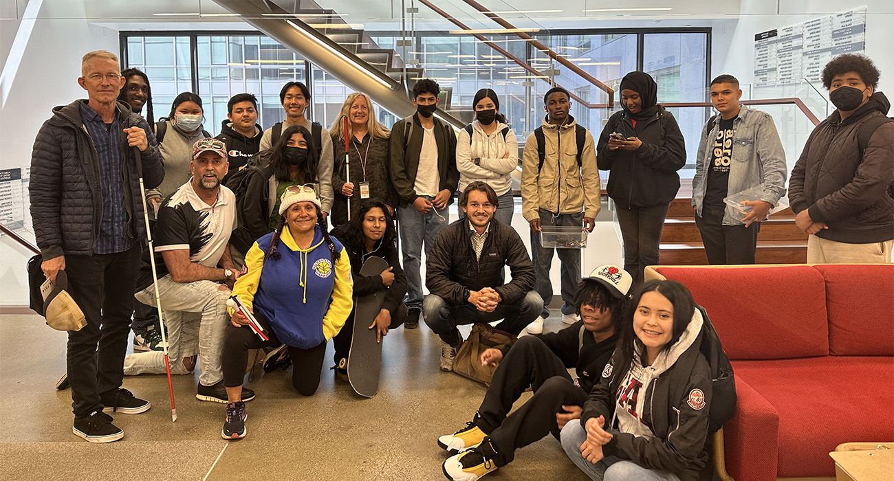 Latitude students and instructor pose with LightHouse community members and staff in front of the 10th floor staircase at LightHouse in 2023.